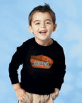 Child wearing a black long-sleeve shirt with 'Queens' printed on it against a blue background