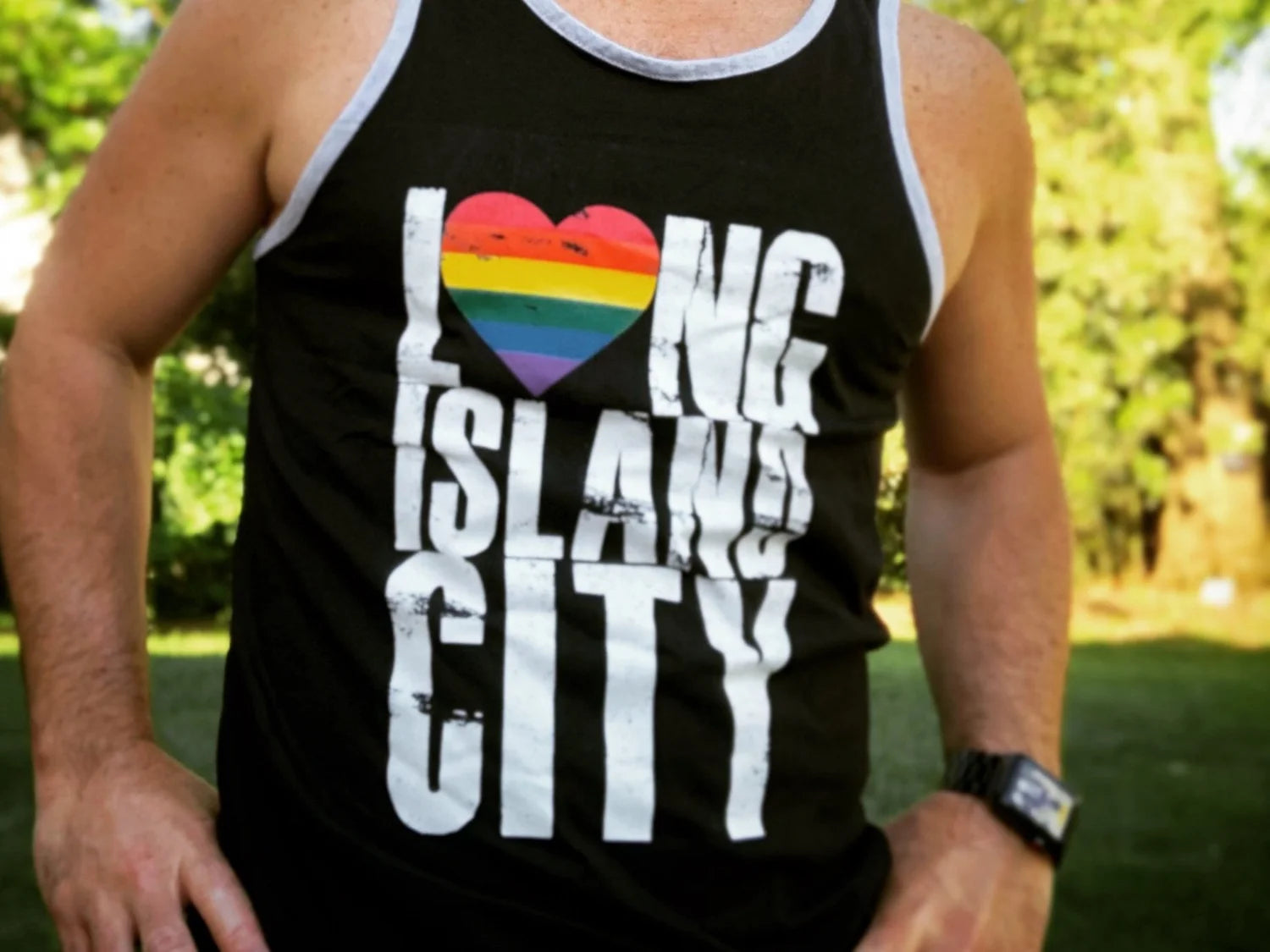 Person wearing a black tank top with 'I ❤️ LONG ISLAND CITY' text and rainbow heart design.