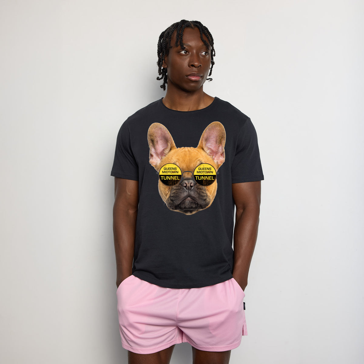Male wearing a gray t-shirt with graphic of dog wearing glasses that say "Queens Midtown Tunnel".