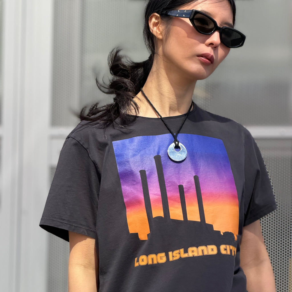 Person wearing a black t-shirt with a colorful graphic and 'Long Island City' text.
