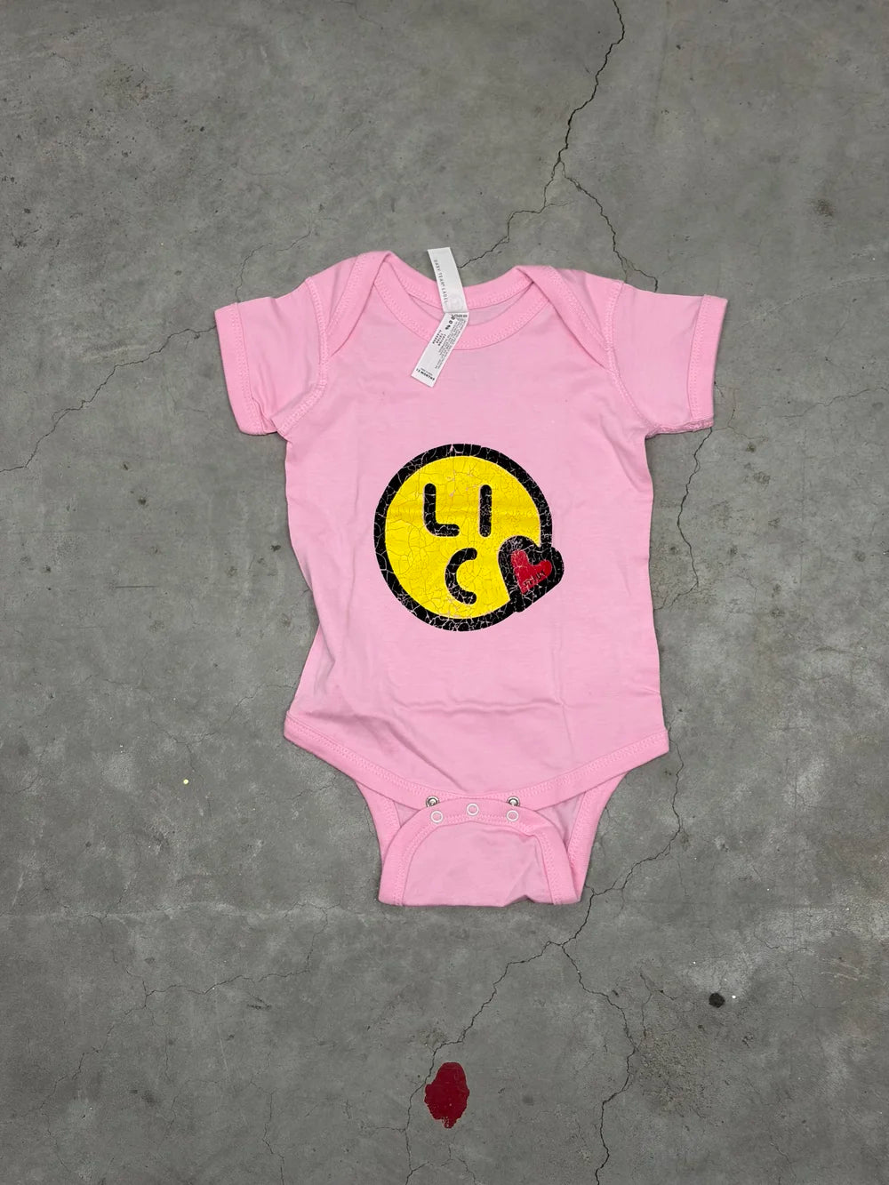 Pink onesie with kiss lic logo