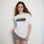 Woman wearing a white t-shirt with colorful text design on a plain background