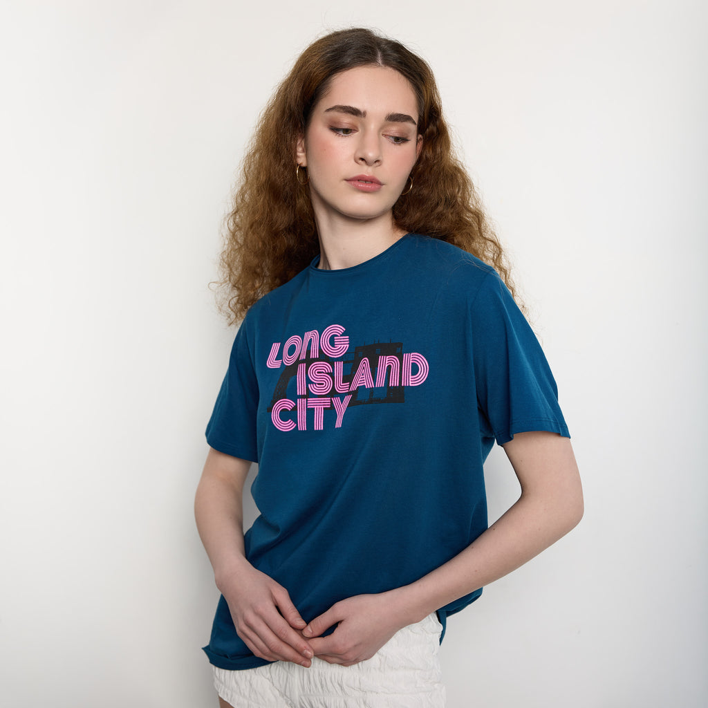 Person wearing a blue t-shirt with 'Long Island City' text on a plain background