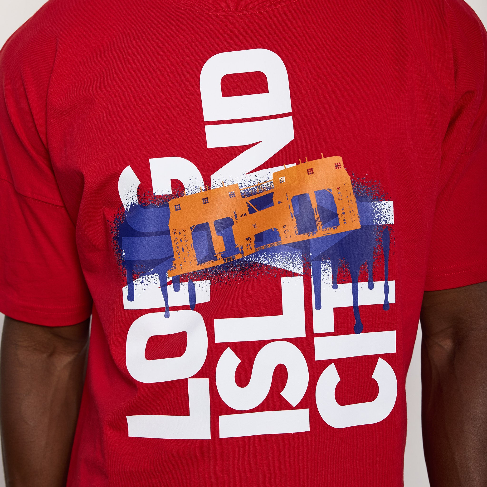 Red t-shirt with graphic design and text on a plain background
