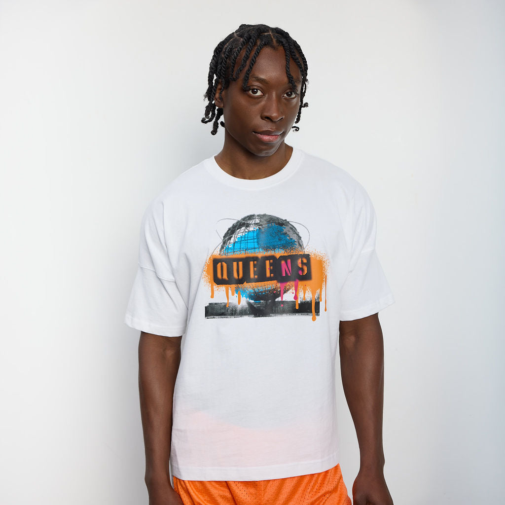 Person wearing a white t-shirt with 'Queens' graphic design on a plain background
