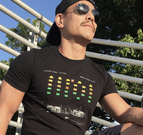 Man with sunglasses wearing a black t-shirt with pixelated graphics outdoors